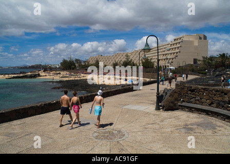Dh COSTA TEGUISE LANZAROTE Beach front les touristes à marcher le long de la promenade de l'hôtel Costa Mar Banque D'Images