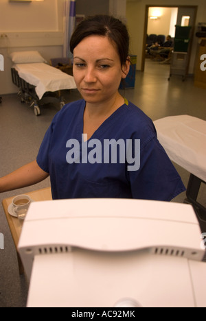 Assistant de soins post opératoires de surveillance des signes vitaux des patients lors d'une unité de chirurgie d'un jour Cobham Surrey Banque D'Images