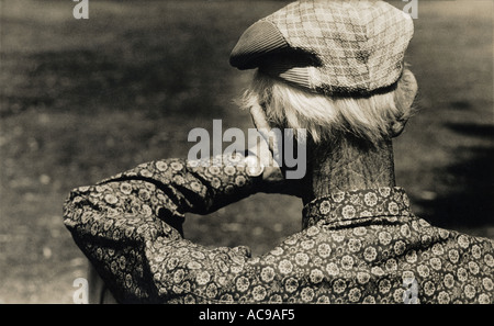 Vue arrière du VIEIL HOMME AVEC FUNKY SHIRT LOOKING AT WATCH Banque D'Images