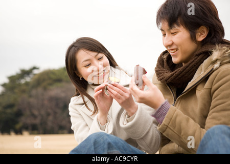 Jeune couple eating sweet potato Banque D'Images