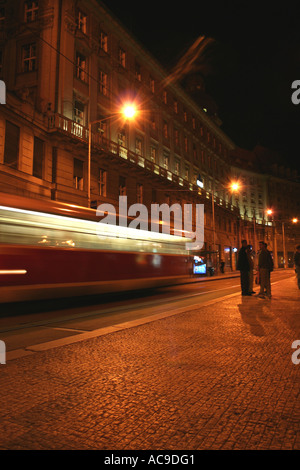 Une traînée de lumière : le tramway passe par une rue nocturne de Prague. Banque D'Images