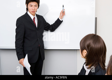 Young businessman standing in front of whiteboard Banque D'Images