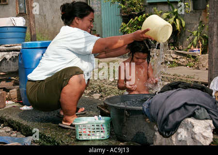 Blanchisserie et lavage par les voies ferrées dans les bidonvilles de Manille, Philippines Banque D'Images