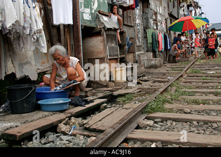 Blanchisserie sur les voies ferrées dans les bidonvilles de Manille, Philippines Banque D'Images