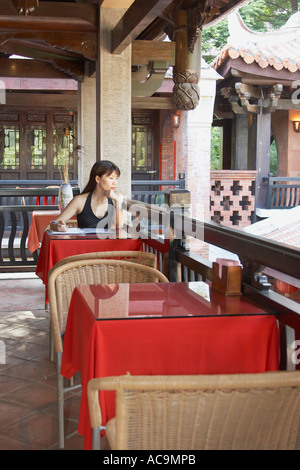 Femme assise dans un salon de thé chinois Banque D'Images