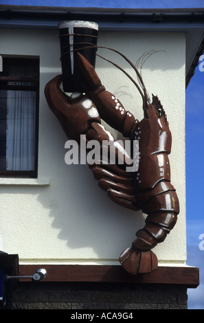 Guinness de rétention de homard vivant dans les griffes d'un Pub Irlandais signe sur la péninsule de Dingle Kerry Irlande Banque D'Images