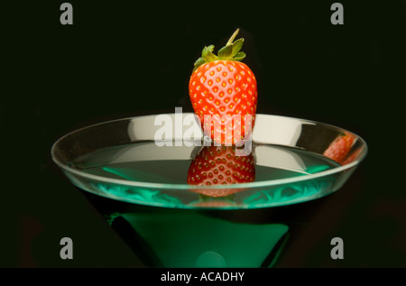Close up avec verre à cocktail martini vert et fraise sur un fond noir - Still Life. Banque D'Images