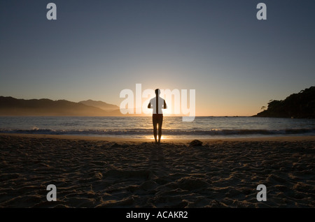 L'homme faisant appel au lever de soleil sur la plage de Rio de Janeiro Brésil Trinidade Banque D'Images