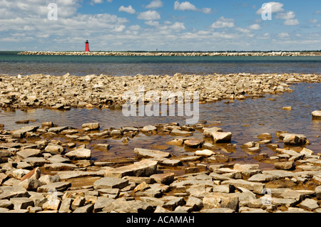 Rochers le long des rives du lac Michigan à Manistique Lighthouse brise-lames est en arrière-plan Manistique au Michigan Banque D'Images