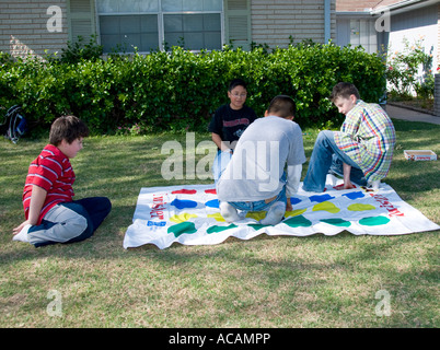 Des garçons ethniquement divers jouant au jeu de retordeuse sur la pelouse pendant l'été. ÉTATS-UNIS. Banque D'Images