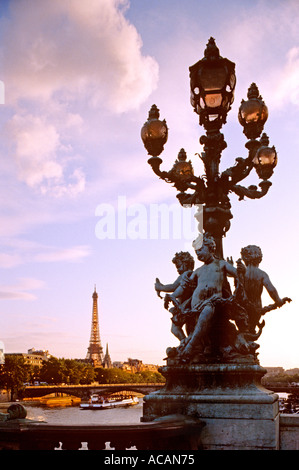 Des lampes sur le pont Alexandre III avec bateau-mouche et la Tour Eiffel en arrière-plan Paris France Banque D'Images