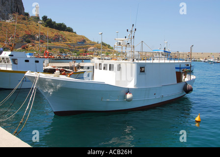 Les bateaux de pêche amarrés dans l'eau claire du port de Cefalù, sur la côte nord de la Sicile Banque D'Images