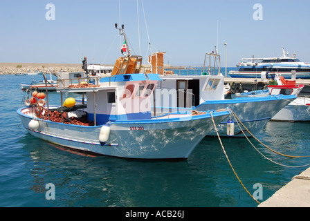 Les bateaux de pêche amarrés dans l'eau claire du port de Cefalù, sur la côte nord de la Sicile Banque D'Images