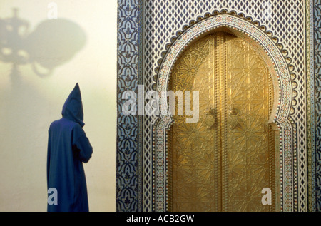 La figure portant une robe traditionnelle marocaine, ou jellabah, approchant le Royal Palace gates, Fes, Maroc Banque D'Images