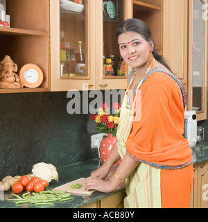 Portrait of a Teenage girl travailler dans une cuisine et souriant Banque D'Images