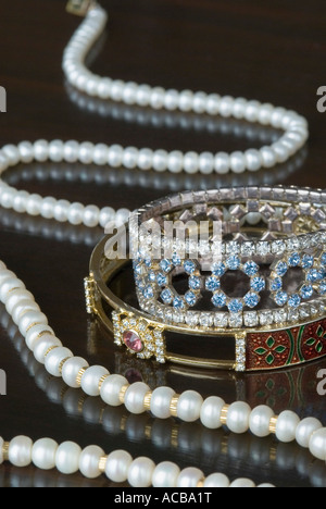Close-up of a pearl necklace avec deux bracelets en or Banque D'Images