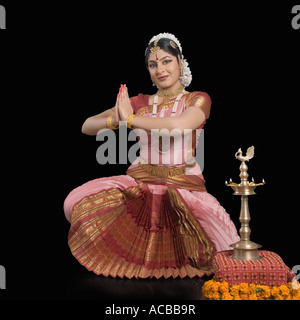 Portrait of a young woman performing Bharatnatyam devant une lampe de cérémonie Banque D'Images