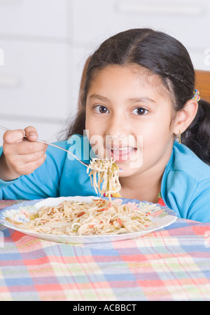 Portrait of a Girl eating spaghetti à l'aide d'une fourchette Banque D'Images