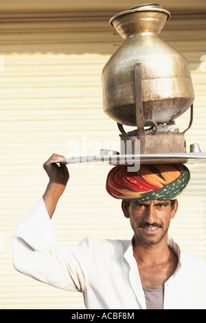 Portrait d'un vendeur portant un pot de thé sur un poêle traditionnel sur la tête Banque D'Images