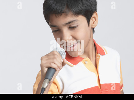 Close-up of a boy chantant devant un microphone Banque D'Images