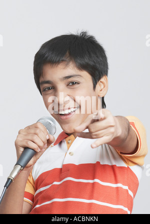 Portrait of a boy chantant devant un microphone Banque D'Images