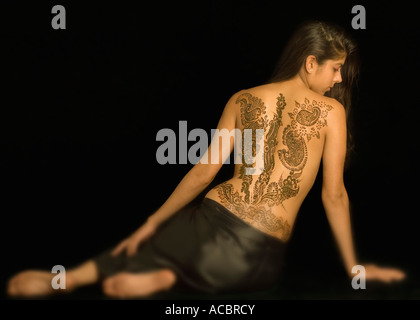 Vue arrière d'une jeune femme avec un tatouage sur son dos Banque D'Images