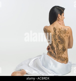 Vue arrière d'une jeune femme avec un tatouage sur son dos Banque D'Images