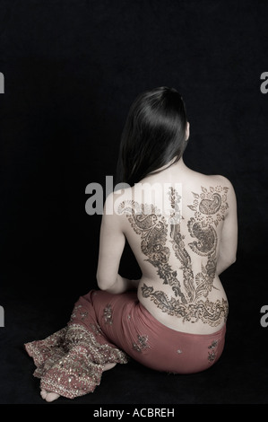 Vue arrière d'une jeune femme avec un tatouage sur son dos Banque D'Images
