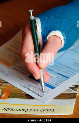 Monsieur l'écriture avec la main dans un bandage en plâtre d'un message à l'assurance accident Banque D'Images