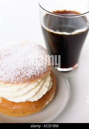 Petit pain à la crème avec du café. Banque D'Images