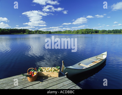 Les pommes et les légumes on lake pier avec canoë sur journée d'été en Suède Banque D'Images