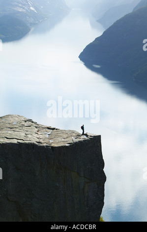 Walker debout sur Preikestolen, ou Pulpit Rock, au-dessus de Lysefjorden, Dale i Sunnfjord, Rogaland,. Banque D'Images