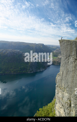 Walker debout sur Preikestolen, ou Pulpit Rock, au-dessus de Lysefjorden, Dale i Sunnfjord, Rogaland,. Banque D'Images