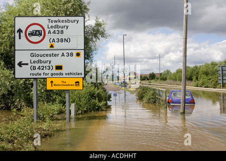 Voitures en partie submergé sur inondés en Newtown Tewkesbury Gloucestershire UK avec panneau routier à Watermeadows Banque D'Images