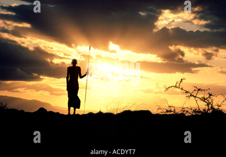 Aîné Rendille silhouetté contre le Ciel de coucher du soleil du nord de l'Afrique de l'Est Kenya Korr Il est porteur d'une lance Banque D'Images