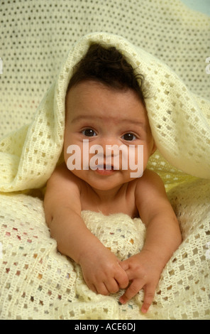 Joli studio portrait mixed race bébé noir sous serviette jaune Banque D'Images