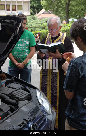 Un prêtre bénit un VW voiture en Roumanie, ce qui porte un tout nouveau sens à l'expression ' prendre la voiture pour un service'. Banque D'Images