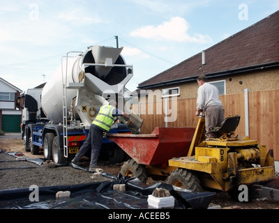 Le malaxeur à béton Camion Camion livraison & pilote sur la construction de nouvelles maisons en béton pour chantier camion dumper sol béton England UK Banque D'Images