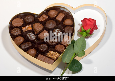 Saint Valentin cadeau de l'or en forme de coeur boîte de chocolats avec une rose rouge et de la tige Banque D'Images