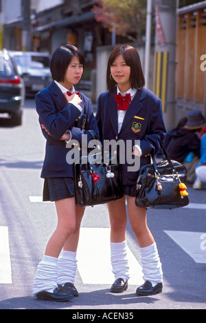 Deux lycéennes en peuplement uniforme sur la rue chatting Banque D'Images