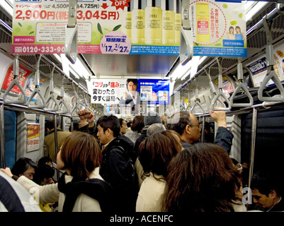 Vue intérieure des navetteurs sur une rame de métro de Tokyo Banque D'Images