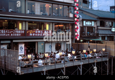 Les terrasses surélevées au bord de la rivière appelées « kawayuka » (川床 ?) offrent une brise fraîche naturelle en été le long de la rivière Kamo à Kyoto, au Japon. Banque D'Images