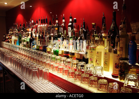 Rangée de bouteilles de boisson alcoolisée sur une pub bar à lunettes, UK Banque D'Images