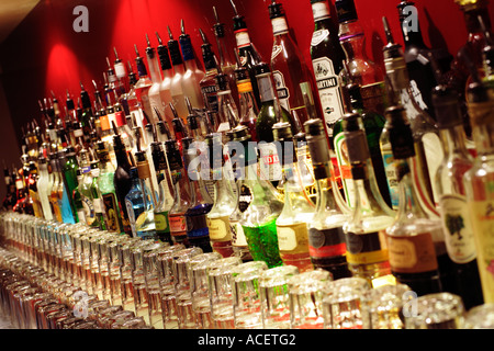Rangée de bouteilles d'alcool et spiritueux derrière un bar avec des lunettes Banque D'Images