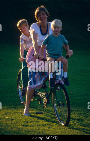 Femme 2 garçons sur le vélo Banque D'Images