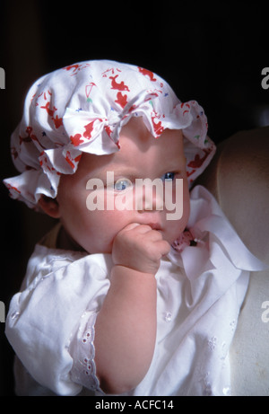 Blonde aux yeux bleus irlandais bébé femelle avec bouchon de coton et robe blanche met au jour les yeux dans l'espace dans le sud de l'Irlande Banque D'Images