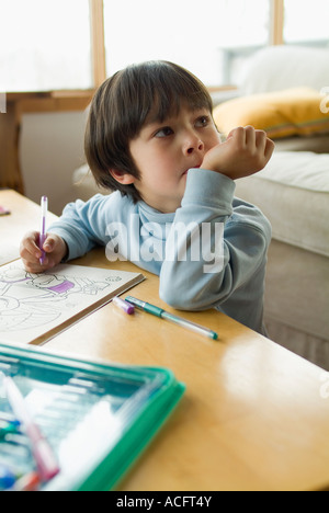 Jeune garçon regarde pendant le dessin et faire de l'artisanat publié Modèle Banque D'Images