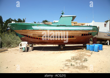 Vieux bateau de pêche coloré hors de l'eau sur l'île de Lampedusa, Sicile, Italie Banque D'Images