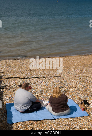 Couple gras seul sur plage face à la mer. Près de Tankerton Whitstable Kent Angleterre HOMER SYKES Banque D'Images