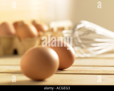 Photo de paysage de 6 oeufs 4 boîte en carton en 2 en premier plan avec wisk métallique tourné sur table en bois à lattes Banque D'Images